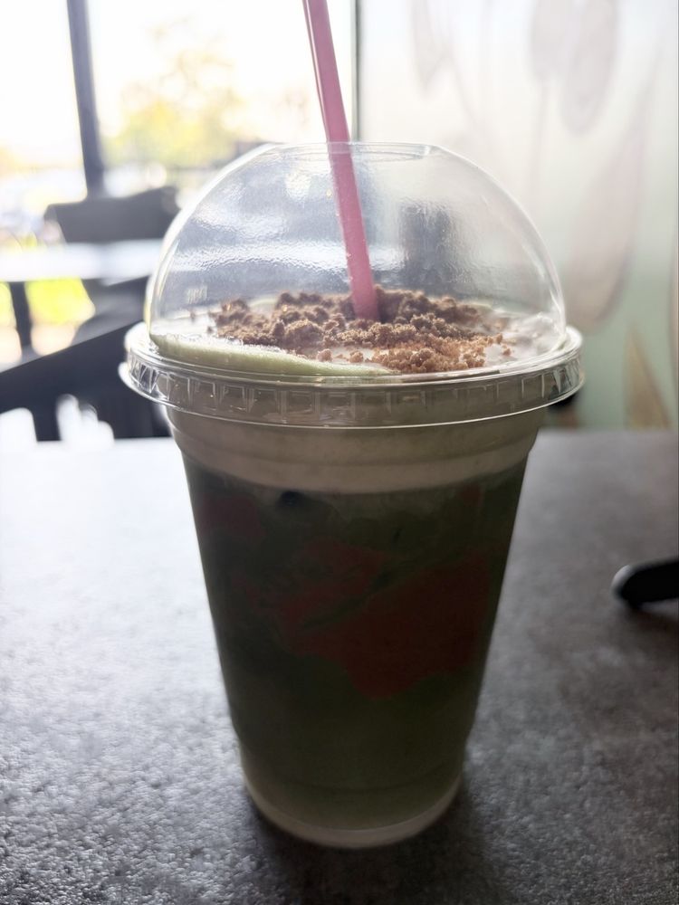 Coffee Wave's iced Biscoff Matcha topped with whipped cream and cookie crumble